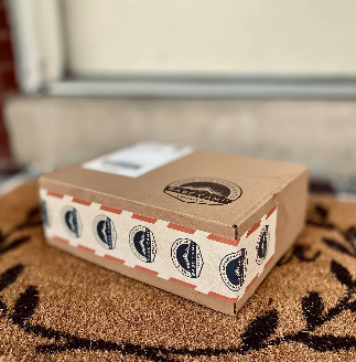 Base Camp Treats Freeze Dried Subscription Box on a mat in front of a door