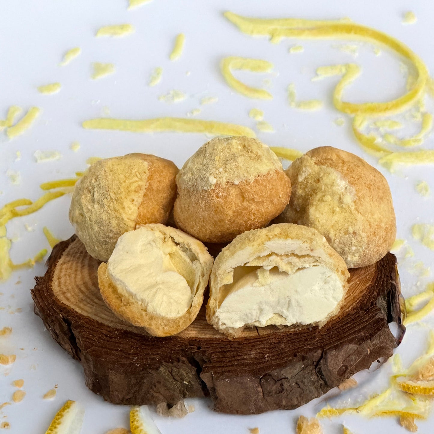 Base Camp Treats Freeze Dried Lemon Cream Puffs on a wooden coaster on a  white background