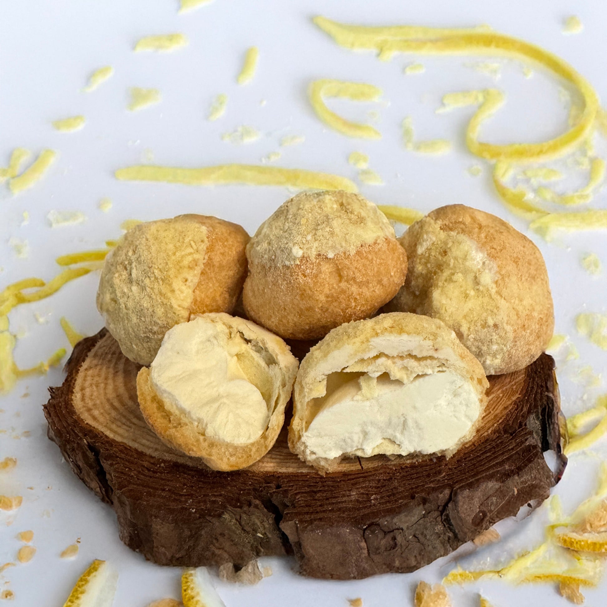Base Camp Treats Freeze Dried Lemon Cream Puffs on a wooden coaster on a  white background
