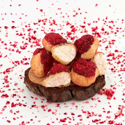 Base Camp Treats Freeze Dried Raspberry Cream Puffs on a wooden coaster on a  white background